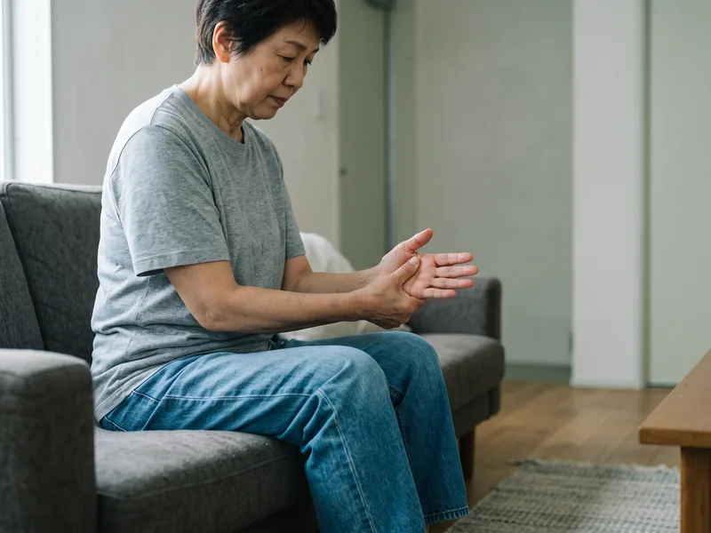A woman rubbing her wrist due to ongoing discomfort at home