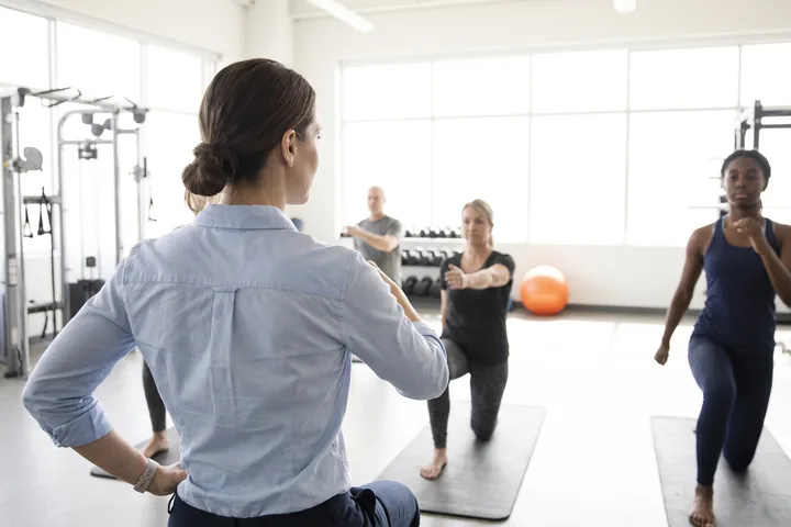 A small group exercise class stretching together in a gym